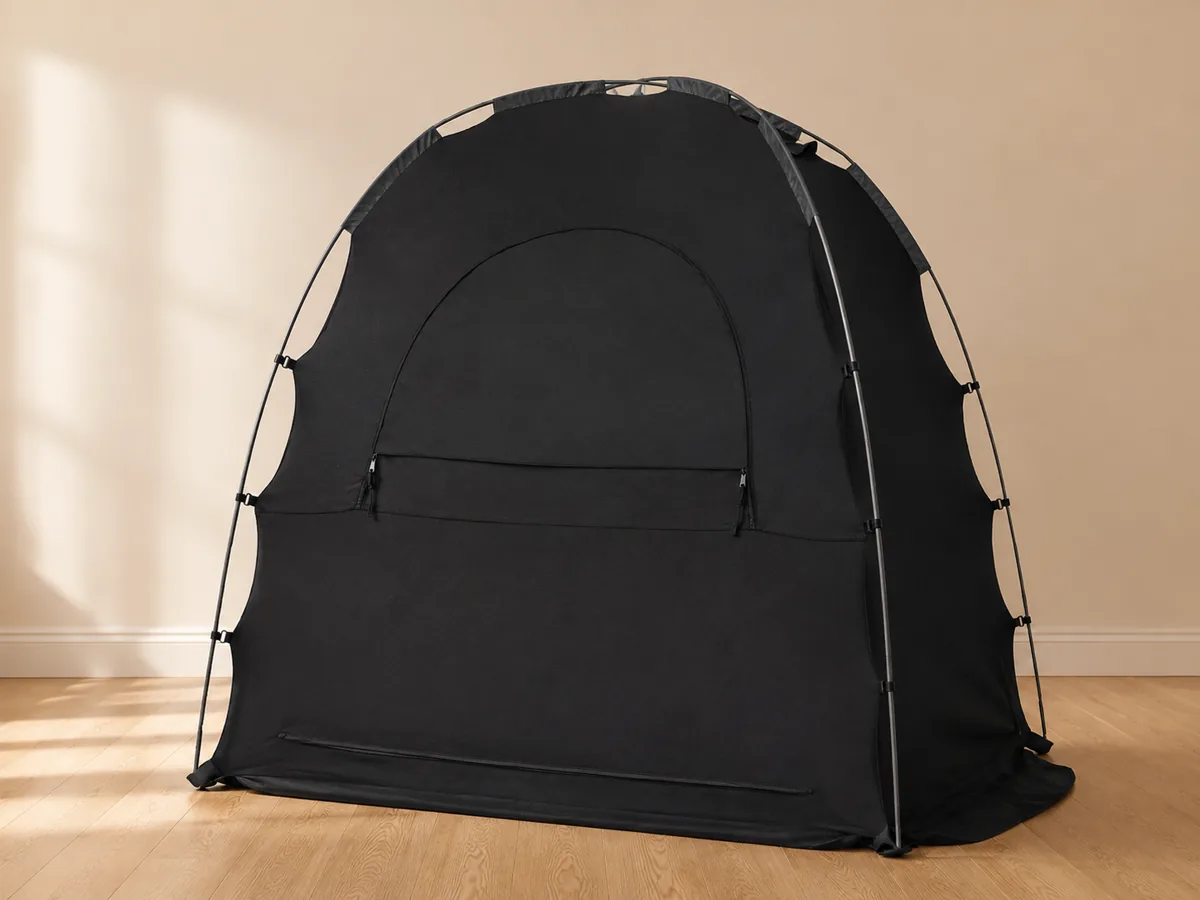 Illustrative guest bedroom with a portable blackout baby sleep tent set up beside the bed